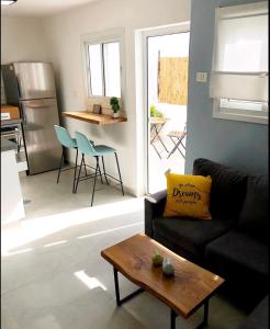 ein Wohnzimmer mit einem Sofa und einem Tisch in der Unterkunft Pninat Hadrom in Be’er Scheva