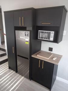 a kitchen with a refrigerator and a microwave at Chardonnay Holiday Apartment in Jeffreys Bay
