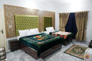 Capry Guest House في كراتشي: غرفة نوم بسريرين في غرفة