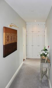 um corredor com paredes brancas e uma mesa com uma planta sobre ele em Riverbank Rooms em Doolin