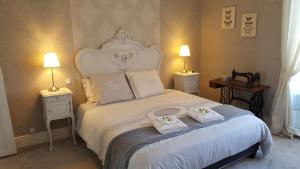 a bedroom with a white bed with two towels on it at La Clef Dort in Beauchamps