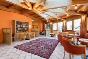 a living room with orange walls and wooden ceilings at OptimaMed Gesundheitsresort Weißbriach GmbH in Weissbriach
