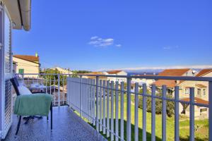 a balcony with a chair and a view of the ocean at Beachfront Summer Oasis Preko in Preko