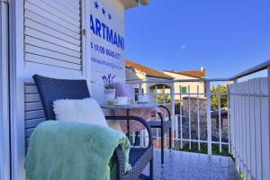 a balcony with a table and chairs on a house at Beachfront Summer Oasis Preko in Preko