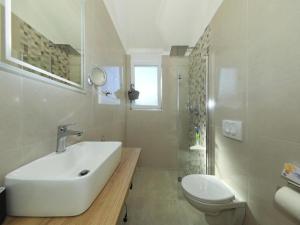 a white bathroom with a sink and a toilet at Apartment Gaby in Božava