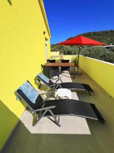 a balcony with a table and chairs and an umbrella at Apartment Gaby in Božava