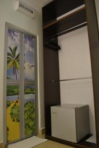 Habitación con puerta corredera de cristal con una foto de la playa en DR Hotel Penang, en Bayan Lepas