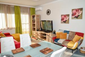 a living room with a couch and a tv at Flamingó Apartman in Hajdúszoboszló