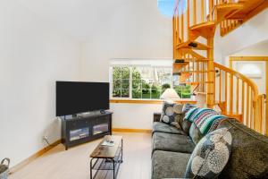uma sala de estar com um sofá e uma televisão de ecrã plano em Alder Cove em Tillamook