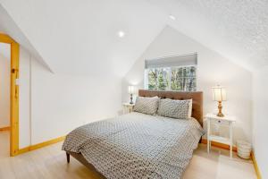 a white bedroom with a bed and a window at Alder Cove in Tillamook