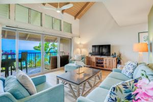 a living room with a couch and a table and a tv at Pali Ke Kua 209 in Princeville