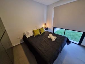 sypialnia z dużym czarnym łóżkiem z żółtymi poduszkami w obiekcie Villa Las Moras w mieście Lujan de Cuyo