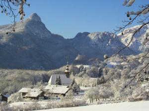 a house in the mountains with a snow covered mountain at Ferienwohnung Meister in Bad Reichenhall