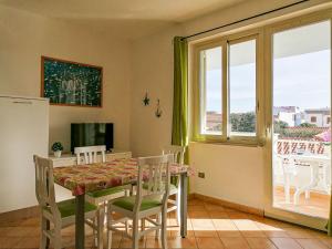 una sala da pranzo con tavolo, sedie e finestra di Residence Levante a Santa Teresa di Gallura