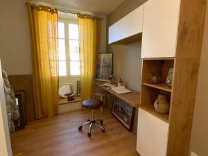 um quarto com uma secretária com uma cadeira e uma janela em Appartement du Port - Audierne em Audierne