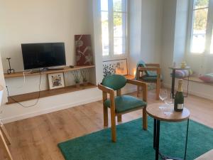 a living room with a tv and chairs and a table at Appartement du Port - Audierne in Audierne