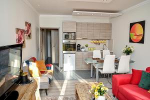 a living room with a red couch and a table at Flamingó Apartman in Hajdúszoboszló