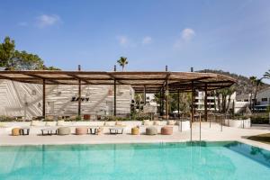 basen z pawilonem z krzesłami i basenem w obiekcie Kimpton Aysla Mallorca, an IHG Hotel w miejscowości Santa Ponsa
