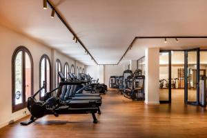 a gym with rows of treadmills and elliptical machines at Kimpton Aysla Mallorca by IHG in Santa Ponsa