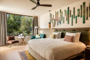 a bedroom with a large bed with a large window at Kimpton Aysla Mallorca by IHG in Santa Ponsa