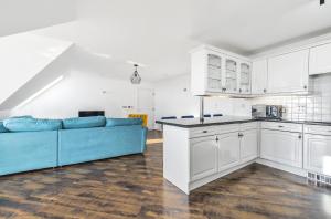 a kitchen and living room with a blue couch at Pochin House Collections in St Austell