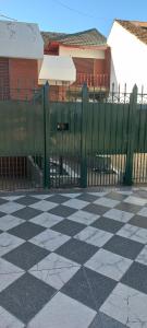 una valla frente a un edificio con suelo a cuadros en Casa Privada Monte Grande y cochera en Monte Grande