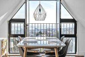 een eetkamer met een tafel en stoelen en een groot raam bij Pochin House Collections in St Austell