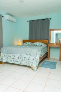 1 dormitorio con cama, mesa y espejo en casa acogedora de 3 habitaciones en Santa Bárbara de Samaná