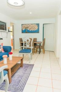 casa acogedora de 3 habitaciones في سانتا باربرا دو سامانا: غرفة معيشة مع أريكة زرقاء وطاولة