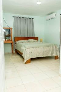 casa acogedora de 3 habitaciones في سانتا باربرا دو سامانا: غرفة نوم مع سرير في غرفة مع مرآة