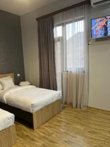 um quarto de hotel com duas camas e uma televisão em NAREMA FAMILY HOTEL MEGHRI em Meghri