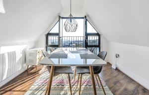 een eetkamer met een witte tafel en stoelen bij Pochin House Collections in St Austell