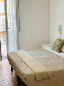 a bedroom with a large bed and a large window at Hotel Lima in Lido di Savio