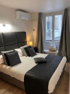 a bedroom with a large bed with black and white pillows at NOTRE DAME - STYLISH APARTMENT in Paris
