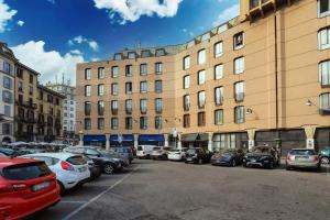 parking z samochodami zaparkowanymi przed budynkiem w obiekcie Duomo Luxury Apartment VIII w Mediolanie