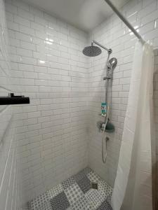 uma casa de banho com um chuveiro com azulejos brancos em The Old Stairs em Sófia