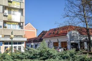 a building with a red roof in a city at Flamingó Apartman in Hajdúszoboszló