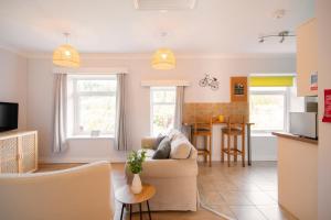 sala de estar con sofá y cocina en The Nook by Afan Valley Escapes, en Port Talbot