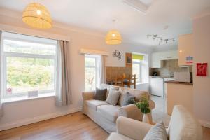 a living room with a couch and a kitchen at The Nook by Afan Valley Escapes in Port Talbot