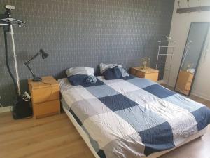 um quarto com uma cama com um cobertor azul e branco em T2 refait à neuf entre Paris et Disneyland Paris em Rosny-sous-Bois