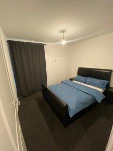 a bedroom with a bed with blue sheets and a window at Luxury Modern 2 bed room apartment. in Belvedere