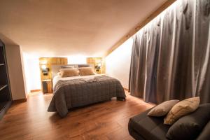 1 dormitorio con 1 cama y 1 sofá en Borda Conangle Mountain Lodge en Sant Julià de Lòria