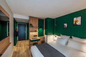 een slaapkamer met een bed en een groene muur bij Les Hauts de Kerano in Paimpol