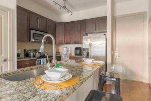 a kitchen with a counter with plates and wine glasses at Home felt apartment- Med Center/NRG in Houston