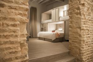 pokój hotelowy z łóżkiem i ceglaną ścianą w obiekcie room00 Salvador Hostel w Sewilli
