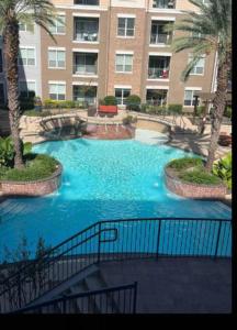 uma piscina com água azul em frente a um edifício em Home felt apartment- Med Center/NRG em Houston