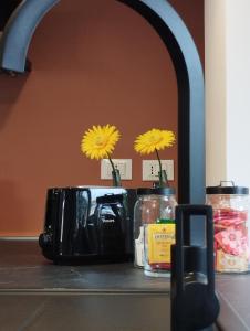 eine Theke mit zwei gelben Blumen in einem Toaster in der Unterkunft A casa di Twiggy in Bologna