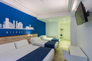 Habitación de hotel con 2 camas y TV de pantalla plana. en Casual Blue en Bilbao