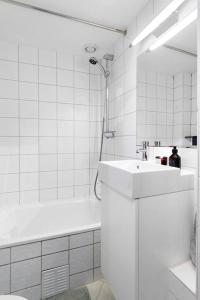 a white bathroom with a sink and a bath tub at Demims Apartments Oslo -- Cozy, Central & Stylish in Oslo