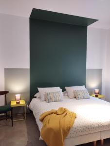 ein Schlafzimmer mit einem großen Bett und einer grünen Wand in der Unterkunft A casa di Twiggy in Bologna